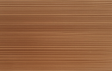 Fototapeta premium A flat brown cardboard texture with a slightly worn look and visible paper grain, offering an authentic feel. The uniform background highlights the cardboard's texture, ideal for base layers and addin