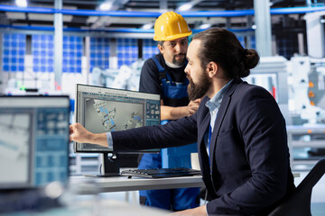 Fototapeta premium Man in photovoltaics factory talking with manager, diagnosing malfunctioning systems. Solar panels manufacturing plant engineer receiving feedback from manager trying to reduce downtime