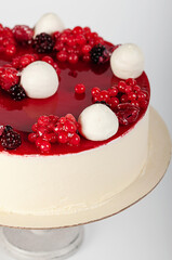 Bright, beautiful red berry cake lying on a cake stand. Isolated image. Cooled cake. Ice cream cake