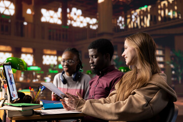 Pupils attend a video conference class lesson in a library for medical science and microbiology, combining remote technology and academic resources to prepare for exams. Diploma in medicine.