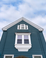 Elegant gable-end house with deep blue-green horizontal siding in Brighton, Massachusetts, USA
