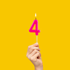 Birthday number 4 - Hand holding fuchsia colored candle