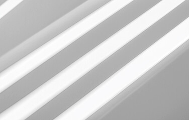 Obraz premium A white background with diagonal lines, soft shadows, and a light texture creates an abstract design. The subtle light and shadow effect makes it ideal for use in mockups, presentations, or designs