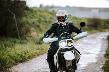 Motorista creando contenido en dia lluvioso en camino de barro inundado