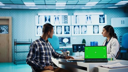 Indian medic consulting her patient in medical facility next to copy space, using advanced technology for scan interpretation and diagnostics. Expert gives advice based on records. Camera B.