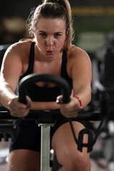 Fototapeta premium A focused fitness woman performing a conditioning workout in the gym, pushing her limits with strength, determination, and intense dedication.
