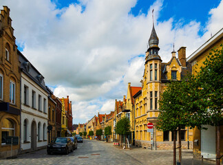 Fototapeta premium Picturesque view of Diksmuide street with typical residential buildings on sunny summer day, Belgium.
