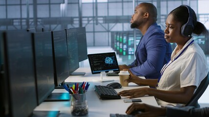 Admin in data center drinking coffee and implementing AI predictive maintenance systems. Server hub...