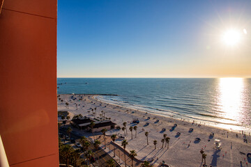a beautiful sunset over the Gulf of Mexico at Clearwater Beach with people relaxing in on the beach in Clearwater Florida USA
