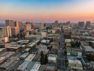Fototapeta premium Aerial view of Oakland, California, USA, at sunset. The photo shows the city's skyline, streets, and buildings, capturing the urban landscape and the transition from day to night.