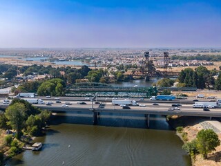 Aerial view of San Joaquin River, Lathrop, California,  USA, with I-5 highway bridge. Cars and trucks are traveling across the bridge, connecting communities and facilitating commerce.