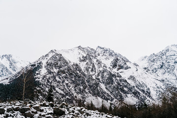 Majestic snow-covered peaks rise above the serene landscape of Kyrgyzstan in winter's embrace