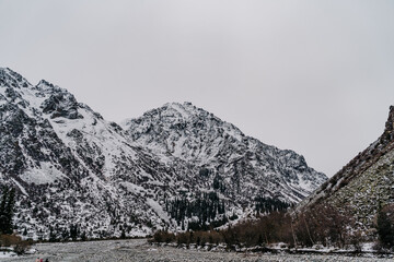 Majestic snow-covered mountains rise above tranquil valleys in Kyrgyzstan during winter's embrace