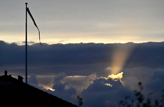 Dramatic Sunset with Rays of Light next danish flag danebrog