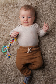 Portrait of infant boy laying on rug.