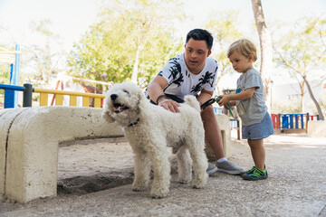 Young man with down syndrome petting dog with a child at playground