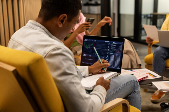 Black man writes notes down in office