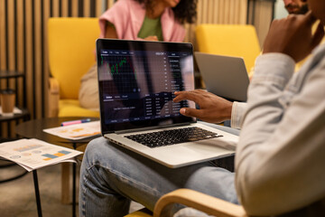 Black man points into screen of laptop