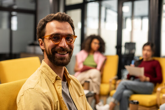 White man with beard and glasses wearing yellow shirt 