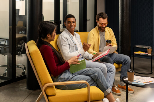 Friendly meeting in office, three people speaking to each other