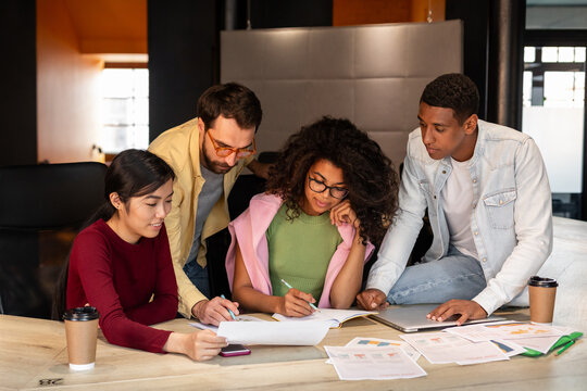 Group of four people solving problem in office