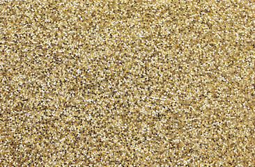 A close-up of a gold glitter texture with shiny golden hues, covered in tiny glitters that catch the light, creating an elegant, luxurious effect. Ideal for festive or glamorous settings conveying opu