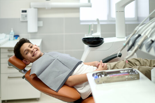 Happy boy sitting in stomatology clinic - Powered by Adobe