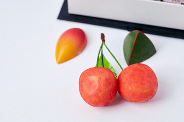 Luxury chocolate assortment in an elegant gift box with decorative cherries and gourmet sweets on a white background  
