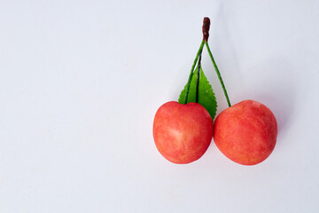 Artistic gourmet chocolates and decorative cherries on a white background with copy space for text  
