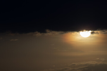 Sunset sky background with clouds. Beautiful nature scene with sun.