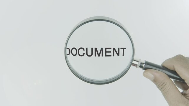 Document text or word highlighted by a magnifying glass in a hand on a white background, symbolizing information, records, and official files