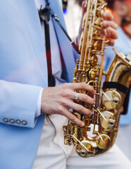 Obraz premium Concert view of saxophonist musician, saxophone sax player with vocalist and musical band during jazz orchestra show performing music on a stage in the scene lights, concert in a musical club hall