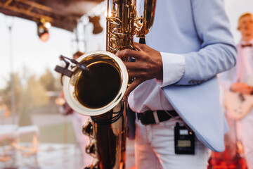 Concert view of saxophonist musician, saxophone sax player with vocalist and musical band during...