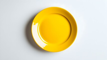 Close up of a round yellow plate on a white