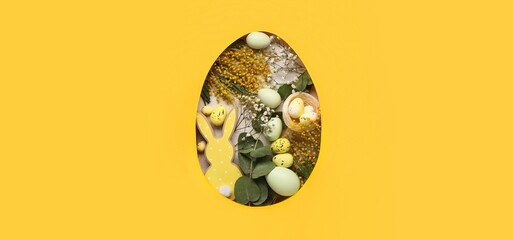Easter eggs, bunny and flowers on yellow background, top view