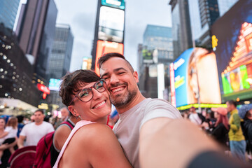 Happy couple taking selfie in Times Square, New York City
