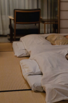 Cozy bedroom setup with futon bedding on tatami mat in the evening