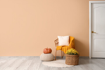 Interior of living room with armchair, pumpkin and chrysanthemum flowers