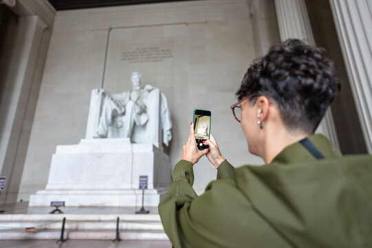 Tourist taking photo of Abraham Lincoln statue at Lincoln Memorial