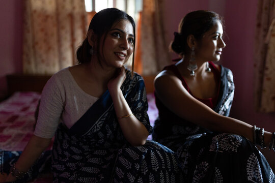 Two Indian woman sitting inside house making conversation