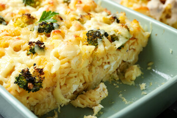 Tasty pasta casserole with cheese and broccoli in baking dish, closeup