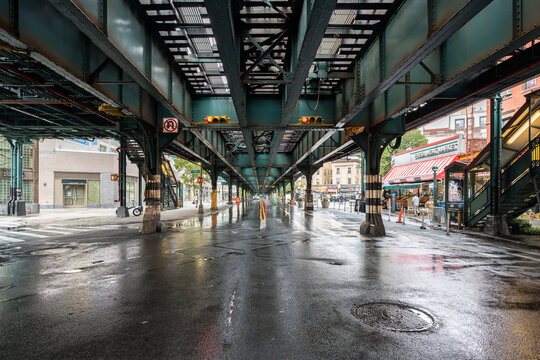 Wet street crossing under elevated railway in New York City