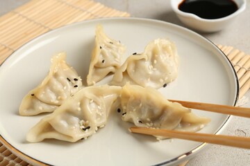 Eating tasty gyoza dumplings at table, closeup