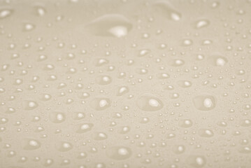 Beige plastic background with water drops.