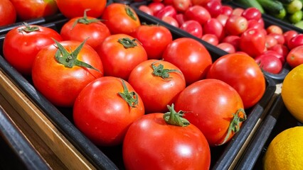 big red tomato displayed in a black tray in the supermarket 