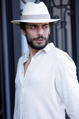 Homem elegante com roupas de verão e estilo de moda com poses e chapeus.