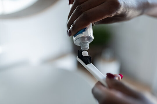 Squeezing toothpaste on brush - Powered by Adobe