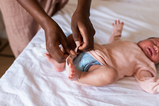 Mother putting on fresh onesie on newborn