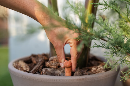 Woman inserting clay worm in pot