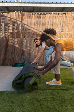 Gardeners decorating terrace with artificial grass